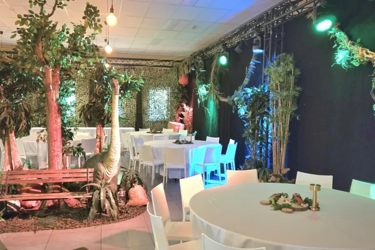 De zaal omgebouwd tot jungle, met kunstbomen, gekleurde verlichting en ronde tafels.